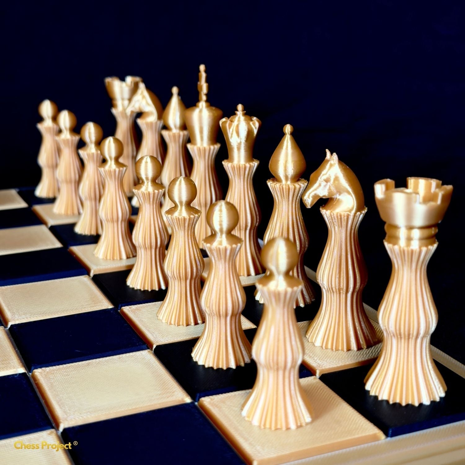 Pièces d’échecs Spiral dorées au design sculptural disposées sur échiquier design