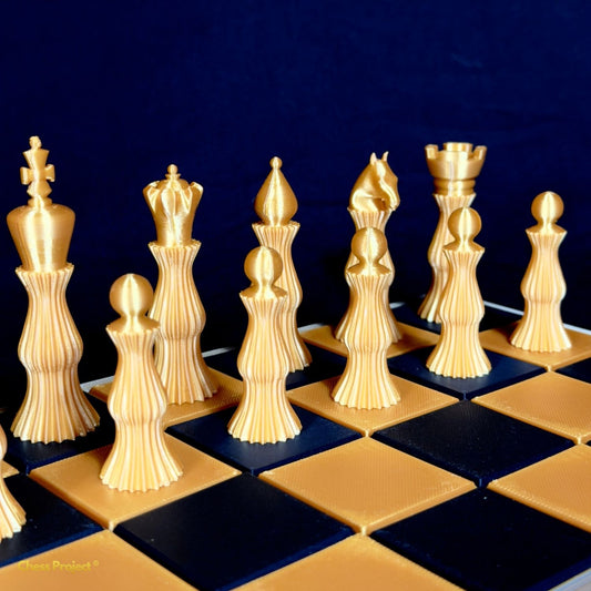 Jeu de pièces d’échecs Spiral design doré aligné sur échiquier contemporain vue latérale