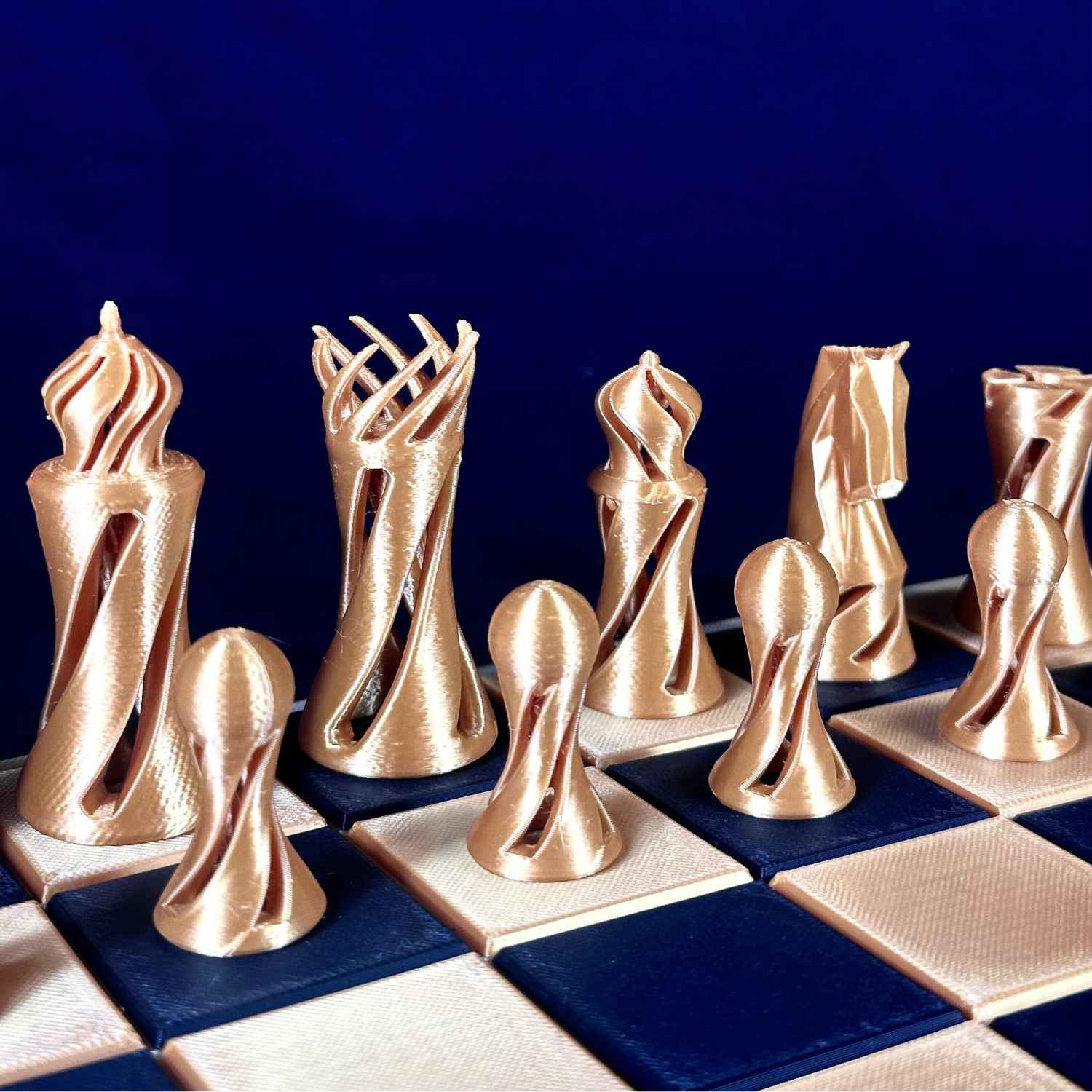 Gros plan sur des pièces d’échecs twist dorées Chess Project, révélant les courbes fluides, la texture et la finition élégante des pièces.